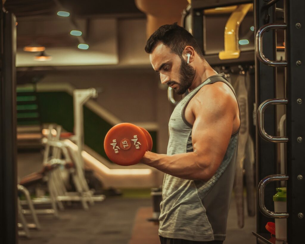 man in gray tank top holding red ball